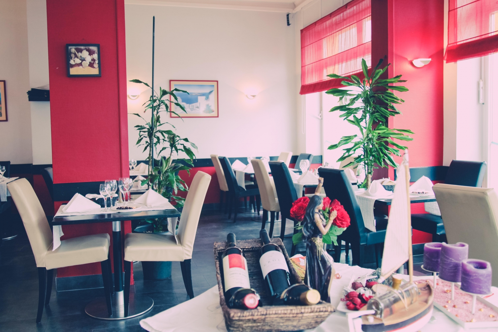 Salle du restaurant Atlantico — murs rouges, chaises en cuir crème, tables dressées