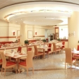Salle de restaurant Chez Fox — chaises rouge-orangé, tables dressées, parquet chaleureux